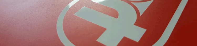 biała tablica dibond zadrukowana czerwonym kolorem - białe litery są w kolorze tablicy kadr ze zdjęcia tablicy reklamowej dibond zadrukowanej drukiem uv